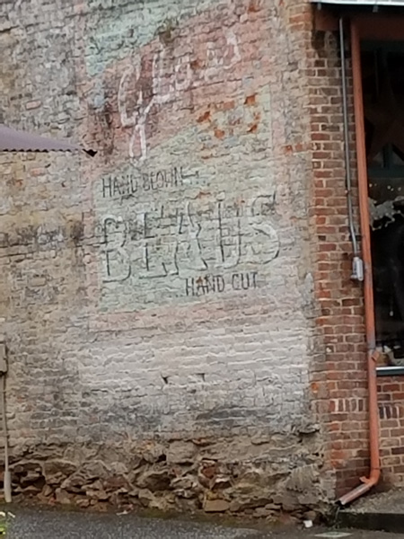 Old "Glass Beads" advertising painted on brick wall.