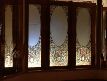 Three stained glass panels, floral design at bottom supporting an oval. Some of the windows that were in the house.
