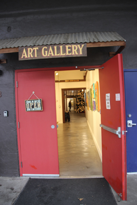 Art Gallery sign over open door, Christmas tree visible at end of a long hall.